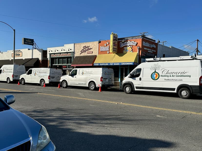 Fleet of Chavarrie Heating & Air Conditioning vans parked outside pet wash and grooming shop.