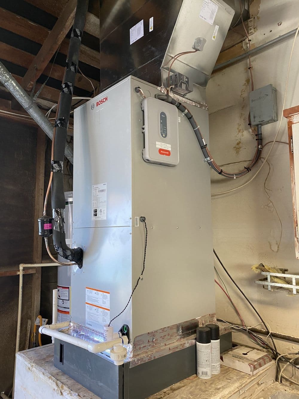 Bosch heating system installed in a utility room with ductwork and electrical connections.