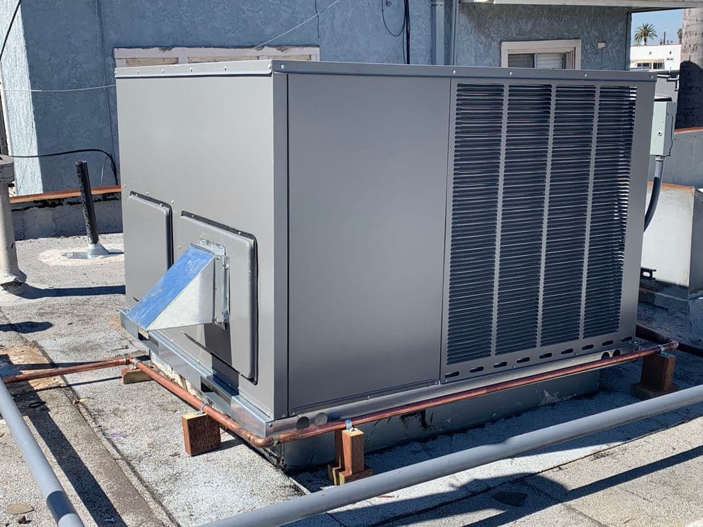 Commercial HVAC unit on rooftop with ventilation duct, designed for efficient climate control.